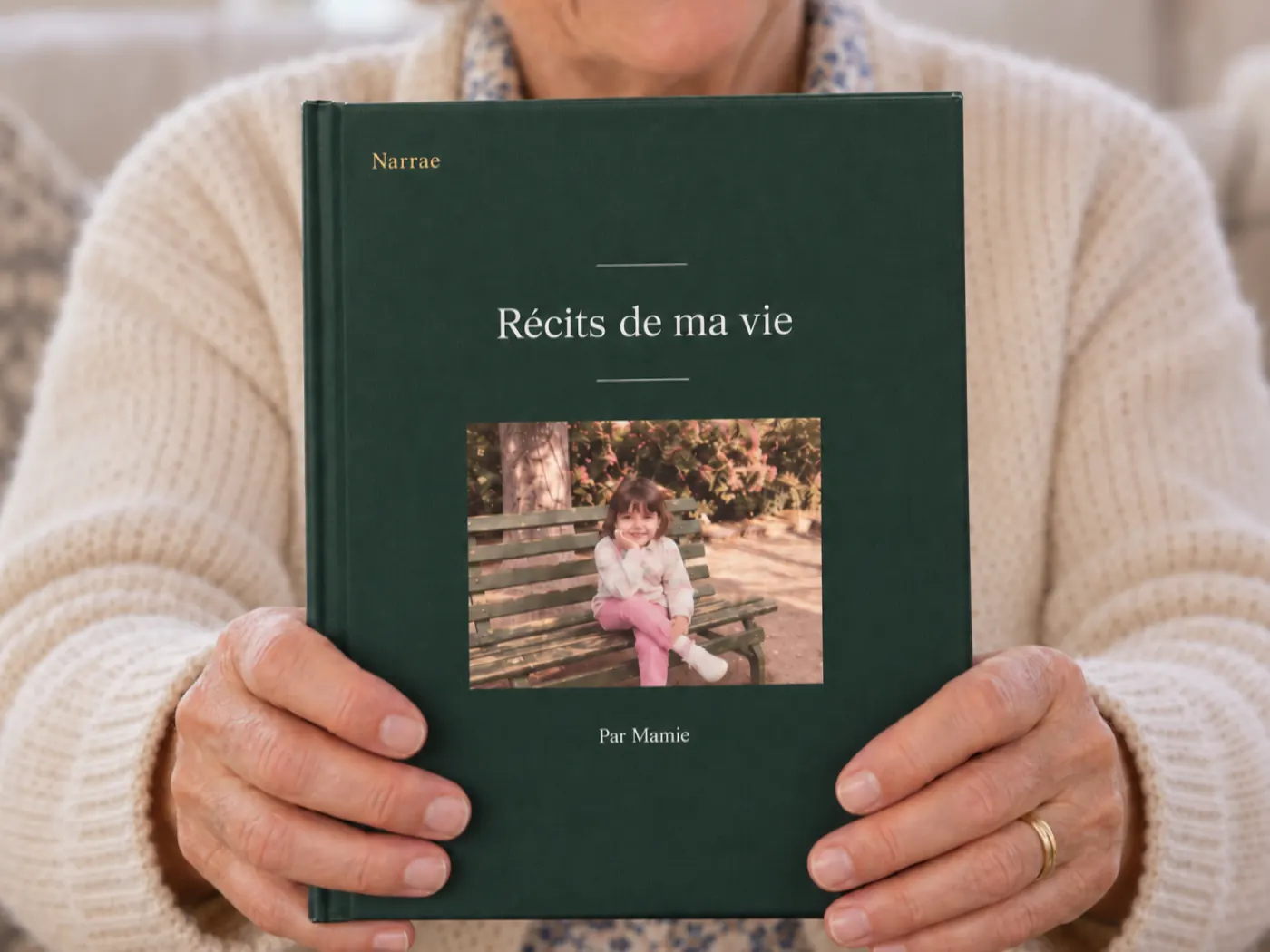 Une femme âgée tient devant elle le livre relié de ses récits.